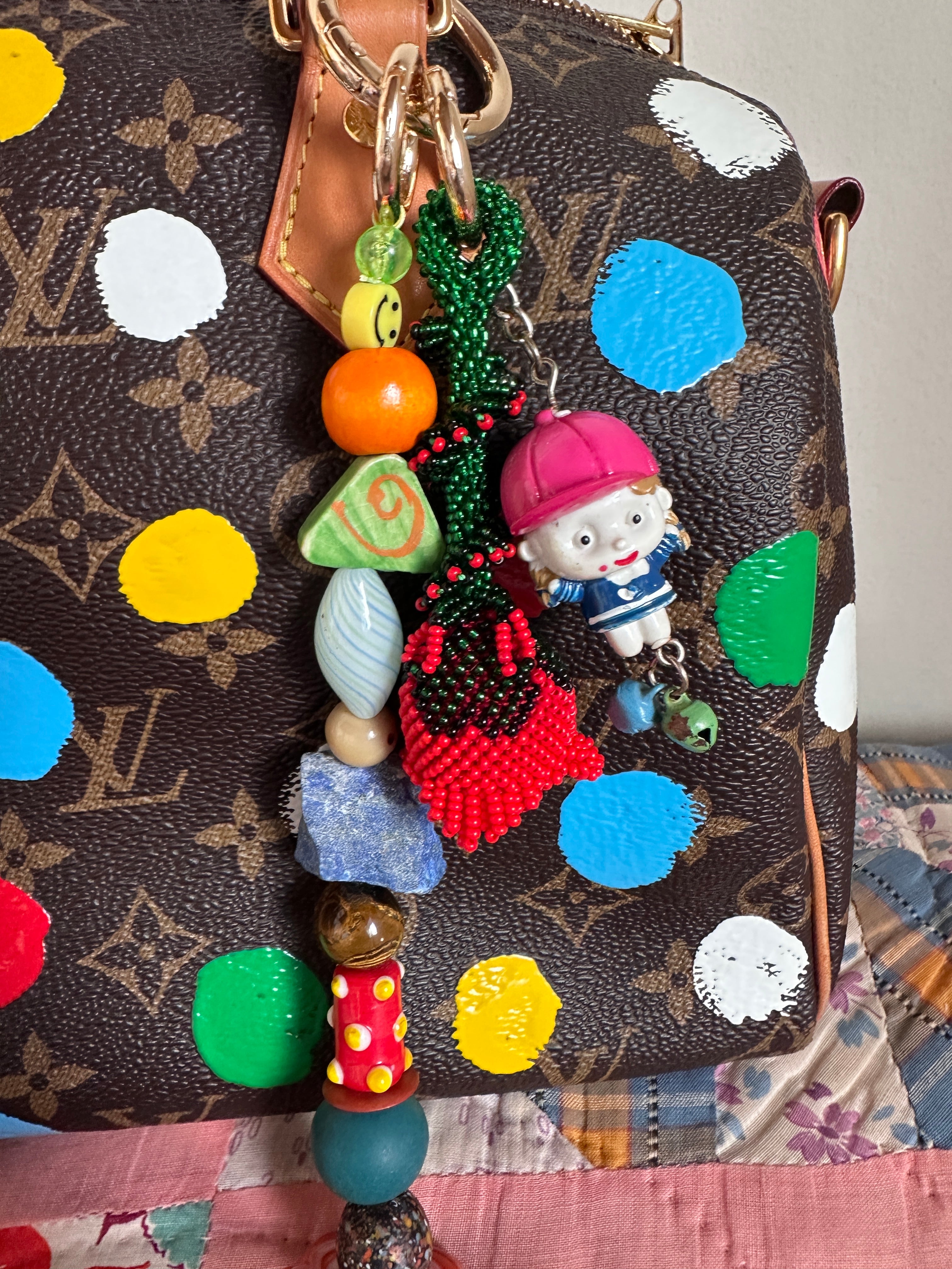 The bag charm with the red rose and the funny little baseball guy