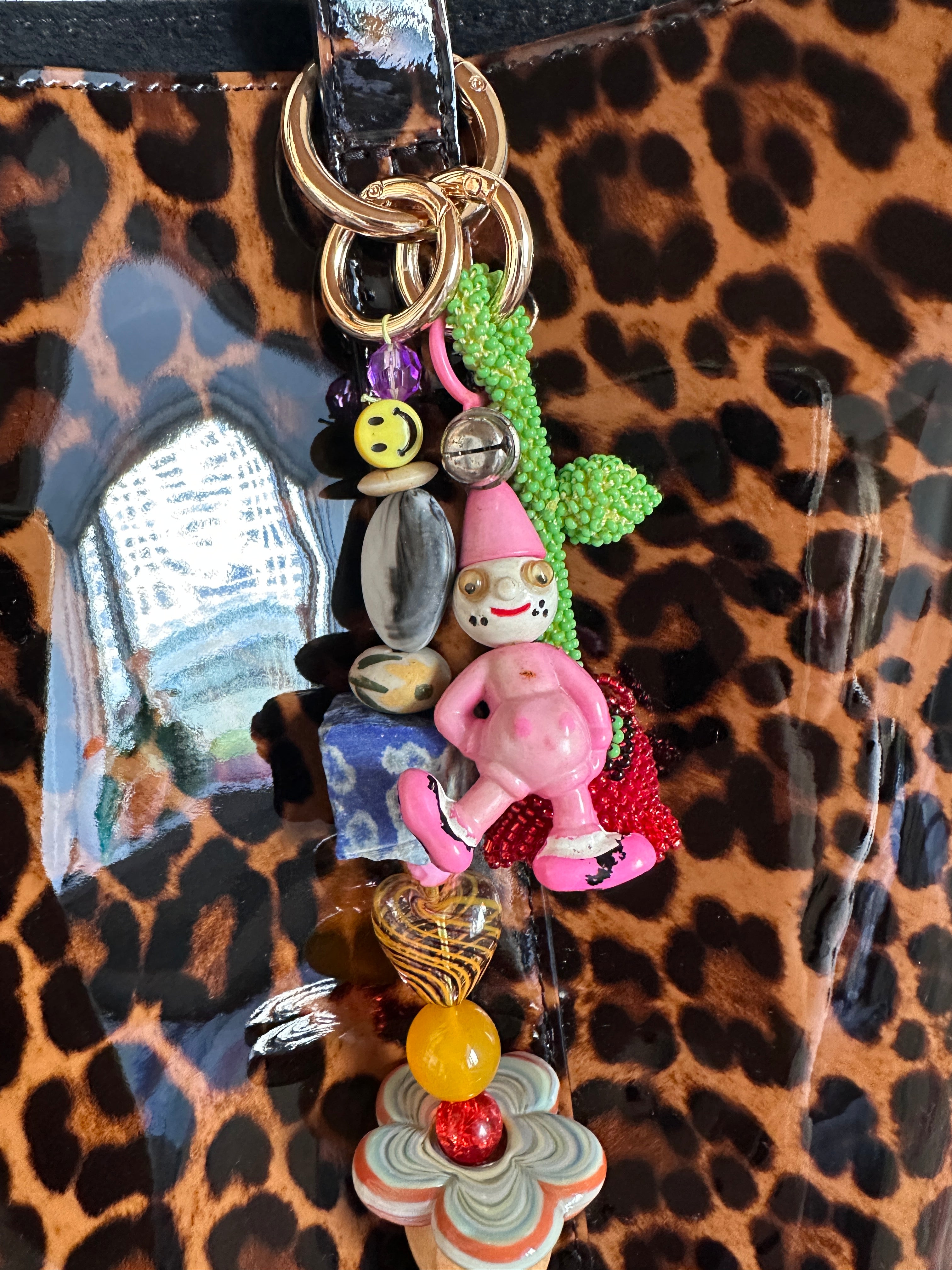 The bag charm with the red rose and the funny pink clown