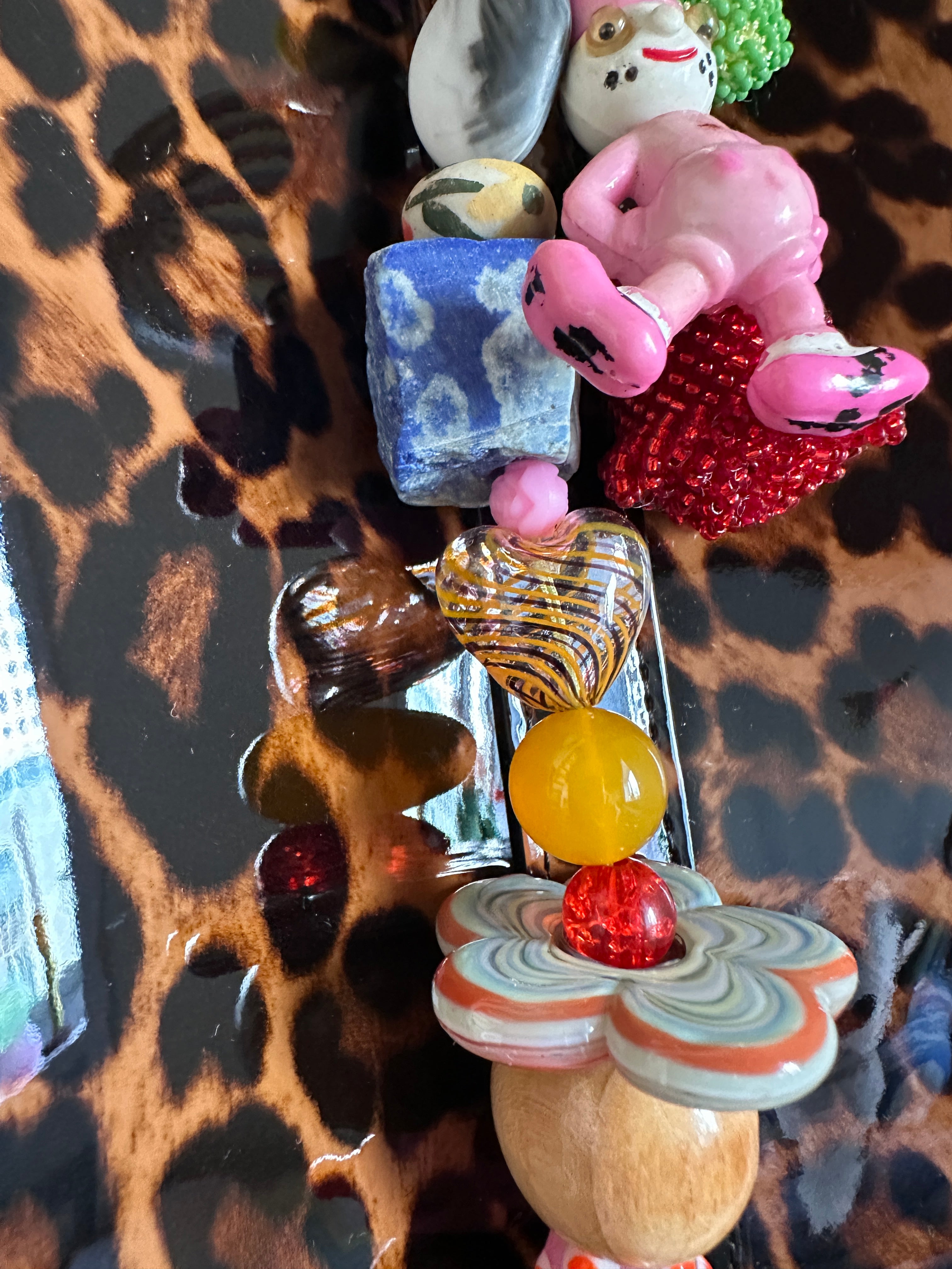 The bag charm with the red rose and the funny pink clown