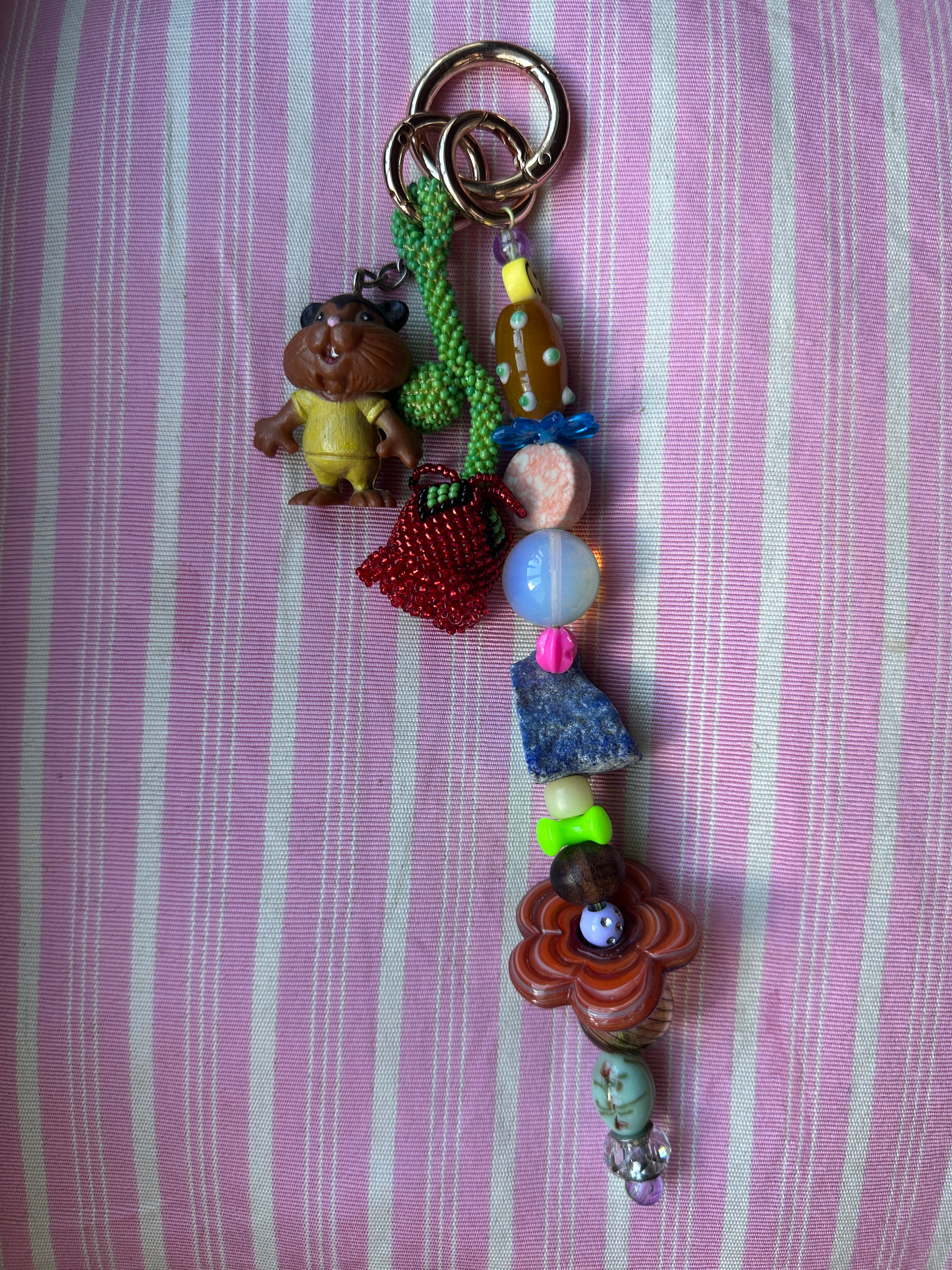 The bag charm with the red rose and the funny beaver