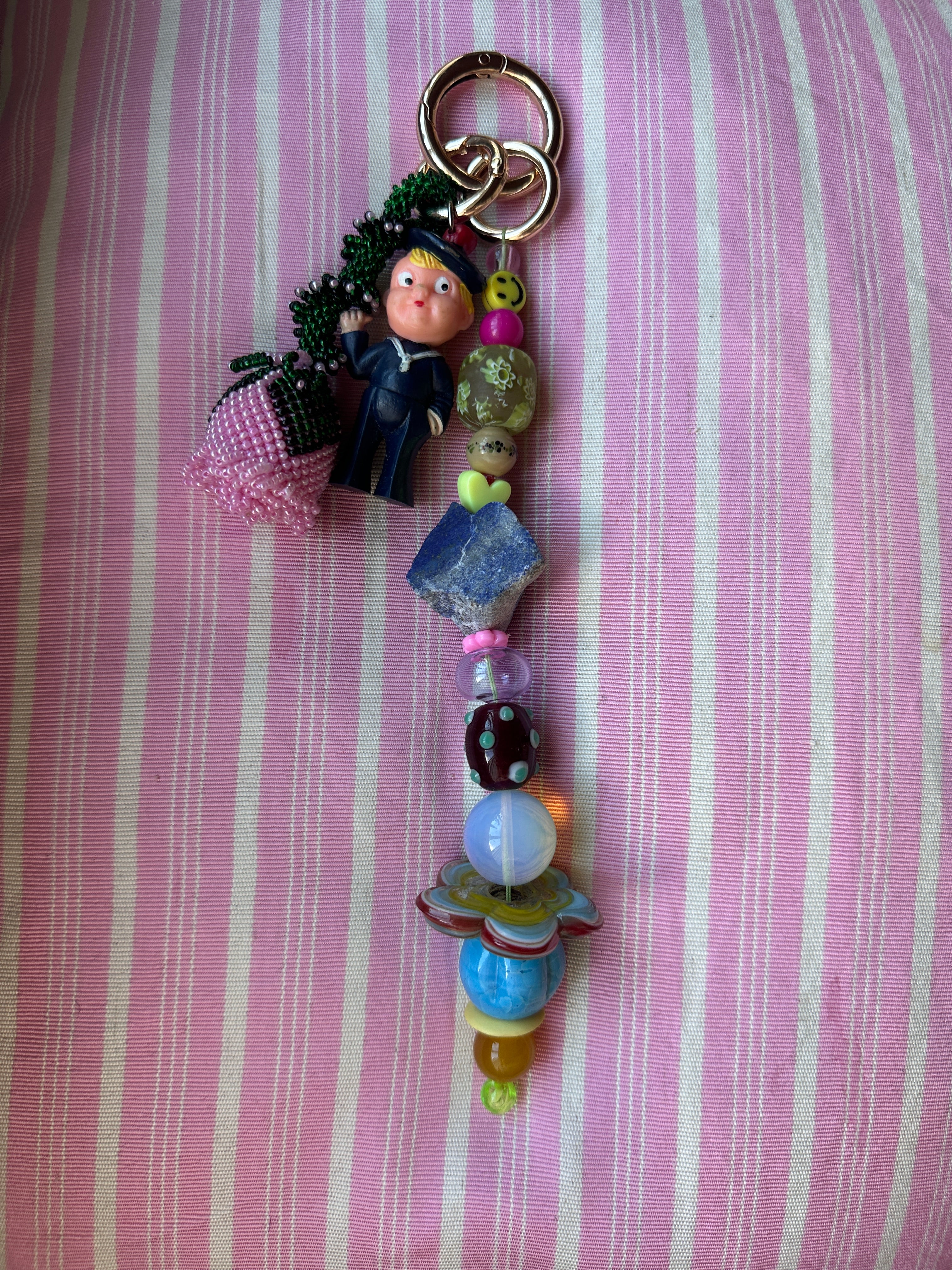 The bag charm with the pink rose and the funny sailor boy